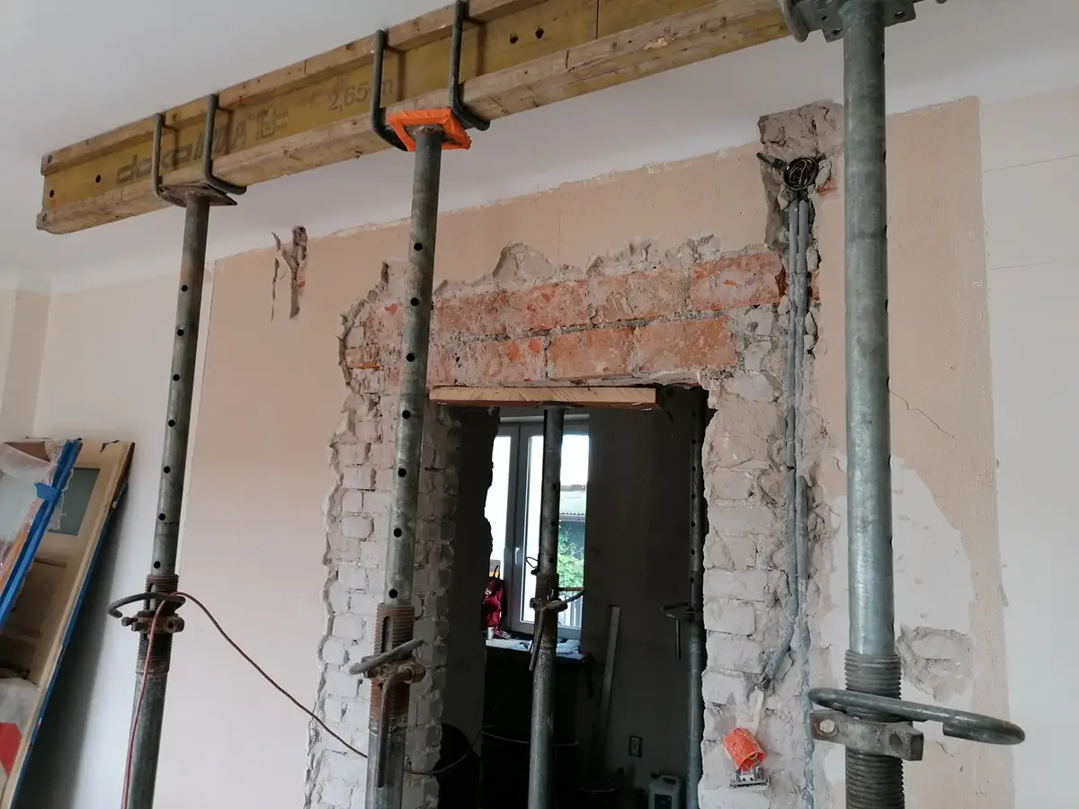 Przebudowa budynków Warszawa — Przebudowa budynku — otwór w ścianie nośnej zabezpieczony stemplami